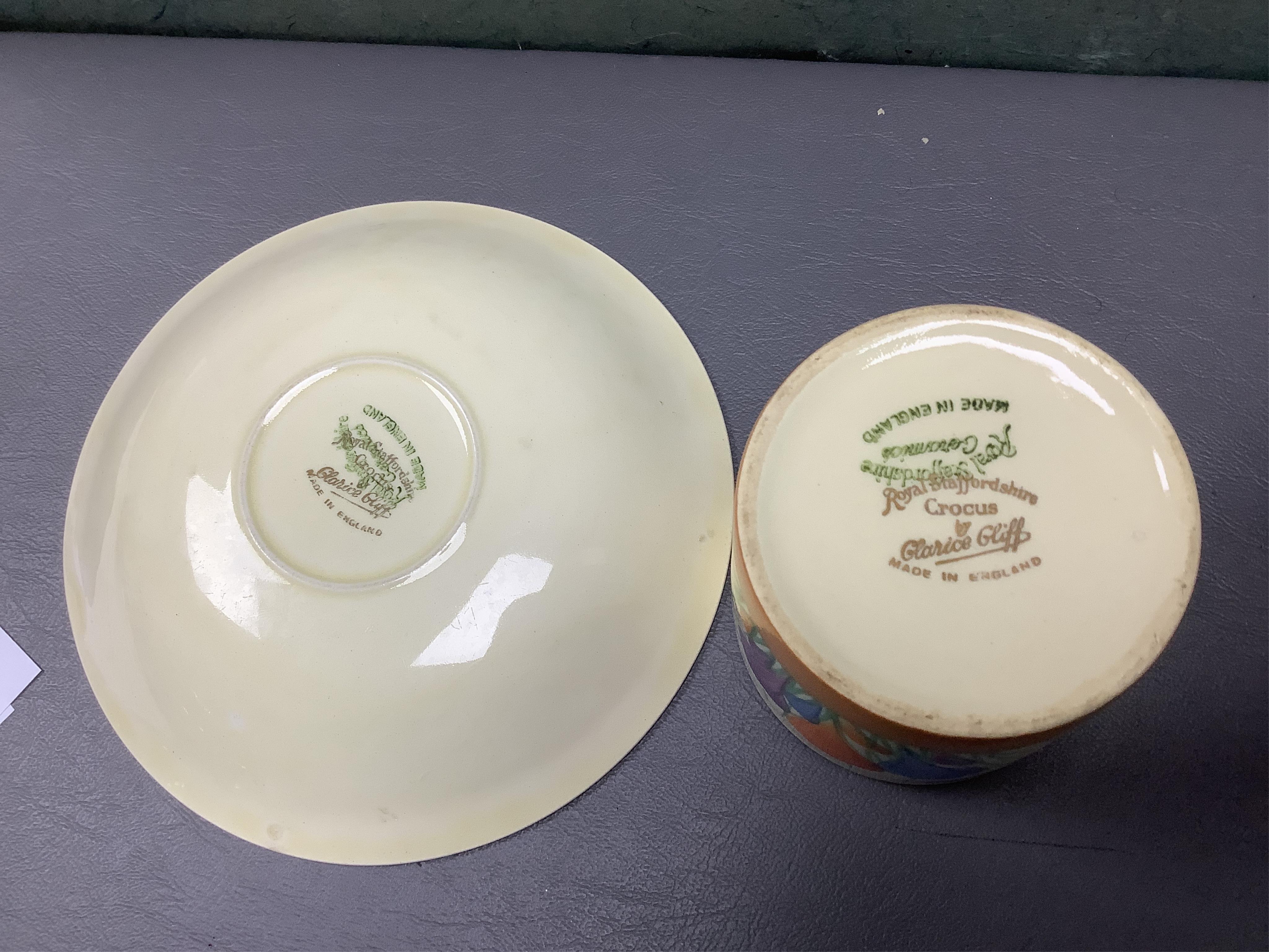 A Clarice Cliff ‘crocus’ pattern preserve jar and cover, 10cm high and a similar cup and saucer